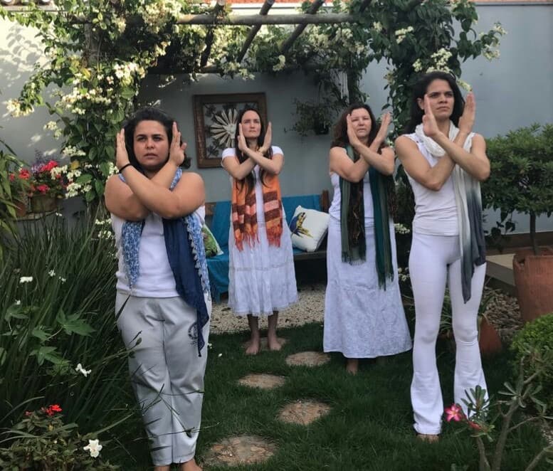 Grupo praticando movimentos sagrados no jardim